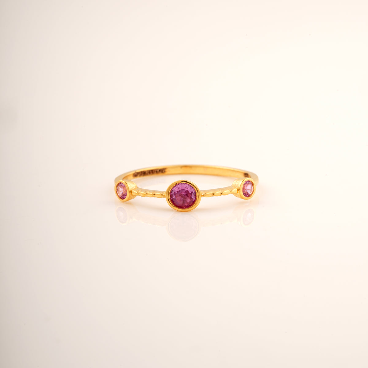 18KT gold ring with three pink gemstones set in a row
