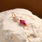 18KT gold pendant shaped like a girl with diamond head and pink stone dress