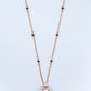 18KT rose gold diamond necklace with black bead accents and woven pendant